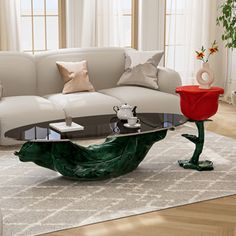 a living room with white couches and red vases on the coffee table in front of it