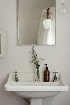 a white sink sitting under a mirror in a bathroom