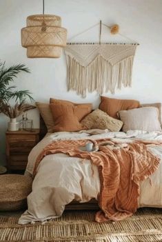 a bed with blankets and pillows in a bedroom next to a plant on the floor