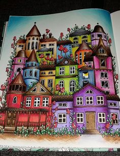 an open book with colorful houses on the cover and in front of it are pictures of buildings