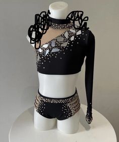 a white mannequin with black and silver clothing on it