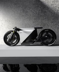 an electric motorcycle parked on top of a white shelf next to a black and white wall