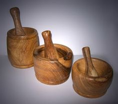 three wooden mortar and pestle sets on a table