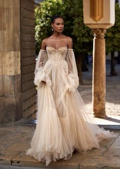 a woman in an off the shoulder wedding dress