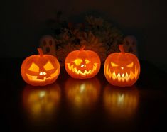 three carved pumpkins sitting on top of a table