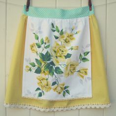 a yellow and white flowered skirt hanging on a wall