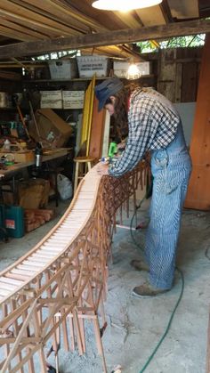 a man working on a wooden bridge in a garage