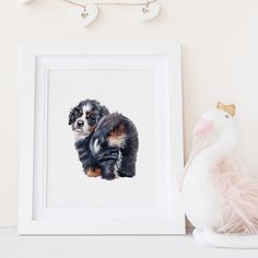 a dog is sitting next to a stuffed animal and a framed photograph on a shelf