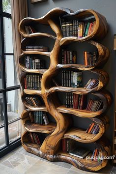 a book shelf made out of wood with books on it's sides and two windows in the background