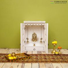 "SKU: TFWT2130 Dimension : L 21\" x D 10\" x H 30\" Mandir Weight: 22 kg Handcrafted solid wood wall mounted pooja mandir with white PU finish, gold & silver brass bells, and antique brass knobs on shutter which enhances your prayer space. Mandir includes: -2 Step with 1 drawer at the bottom -2 Shutters and a back -Gold & silver brass bells -2 antique brass knobs on the shutters -1 Antique brass handle on the drawer -2 Small hanging brass lamps of 4\"dia and 7\" height with 20\" chain All essent Puja Unit, Pooja Unit, Brass Lamps, Home Decor Indian, Mandir Design, Temple Design For Home, Wood Kiln, Pooja Mandir, Brass Knob