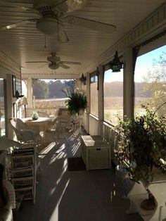 a porch with wicker furniture and ceiling fans