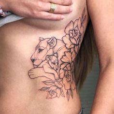 a close up of a woman's stomach with tattoos on her body and flowers