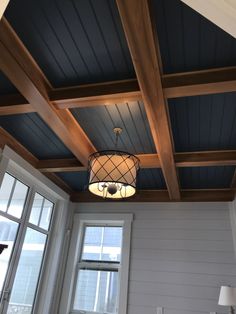 the ceiling in this room is painted blue and has wood trimmings on it