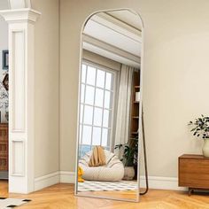 a large mirror sitting on top of a wooden floor