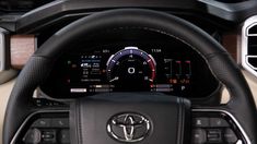 the interior of a car with steering wheel and gauges