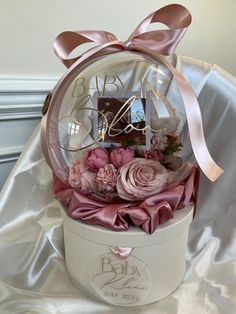 a baby's first birthday gift in a round box with pink flowers and ribbons