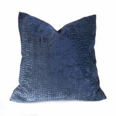 a blue pillow on a white background with a black square pattern in the center and bottom