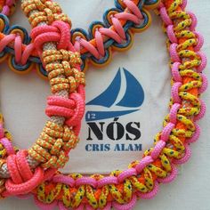 two bracelets made out of rope and colorful beads on a white cloth with no's logo in the background