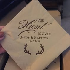 a person holding up a napkin with the words, the hunt is over and antlers on it