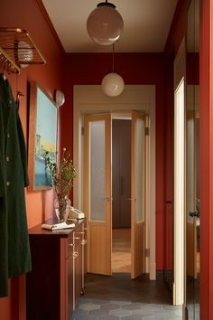 a hallway with red walls and wooden doors