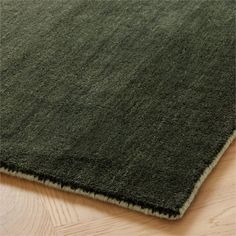 a green rug on top of a wooden floor next to a wood flooring board