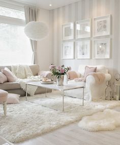 a living room filled with white furniture and lots of windows