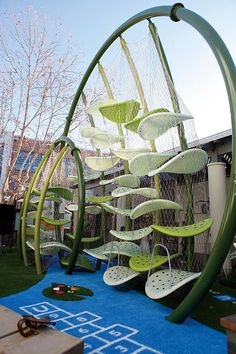 an outdoor play area with green and white chairs