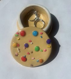 two rings are sitting in a small bowl with sprinkles on the surface