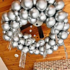 a wreath made out of silver balloons hanging from the ceiling