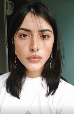 a woman with freckled hair is looking at the camera and has teary eyes