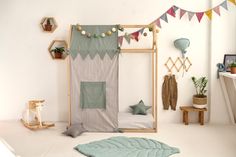 a child's bedroom decorated in pastel green and grey colors with bunting