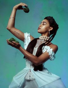 a woman in a white dress holding broccoli and looking up at the sky