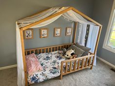 a child's bed with a canopy over it in a room that has carpeted floors and walls