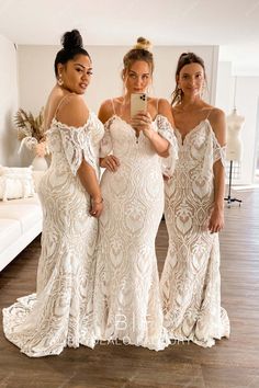 three women in white dresses are taking a selfie with their cell phone while standing next to each other