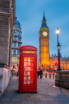 the big ben clock tower towering over the city of london, england at dusk with red telephone booths