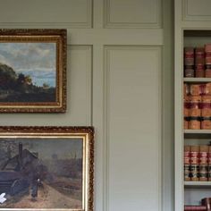 two bookshelves with paintings on the wall