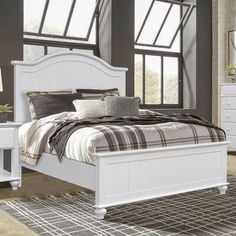 a white bed sitting inside of a bedroom next to a night stand and nightstands