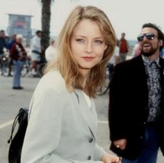 a woman standing next to a man in a suit and tie on a street corner