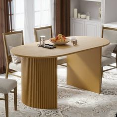 a dining room table with chairs and a bowl of fruit on the plate next to it