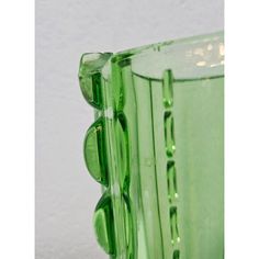 a green glass vase sitting on top of a table