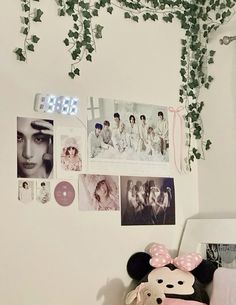 there is a wall with many pictures on it and a stuffed animal in the corner