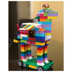 a toy horse made out of legos sitting on top of a table next to a wall