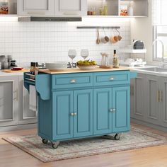 a blue kitchen island in the middle of a wooden floor