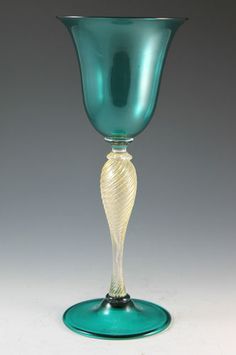 a green glass vase sitting on top of a table