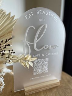 a glass award sitting on top of a wooden table next to dried flowers and leaves