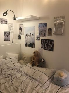 a teddy bear sitting on top of a bed in a room filled with pictures and posters