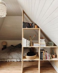 an attic bedroom with bookshelves and a bed