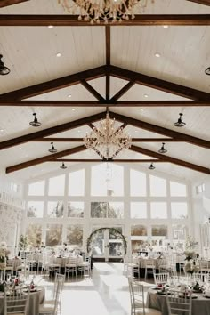 an indoor wedding venue with chandeliers and tables