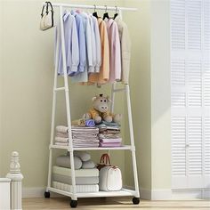 a white rack with clothes and a teddy bear