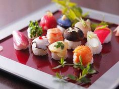 a plate with sushi and vegetables on it